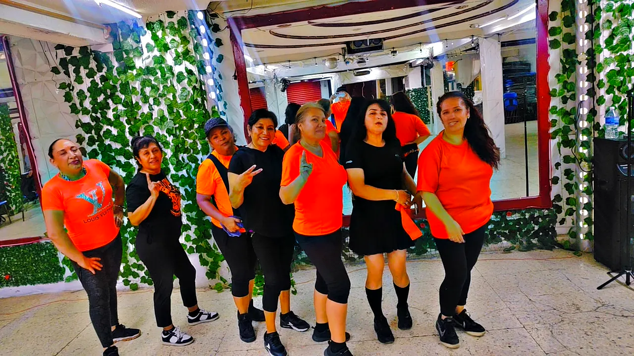 Alumnas con playeras naranjas posando al terminar la clase