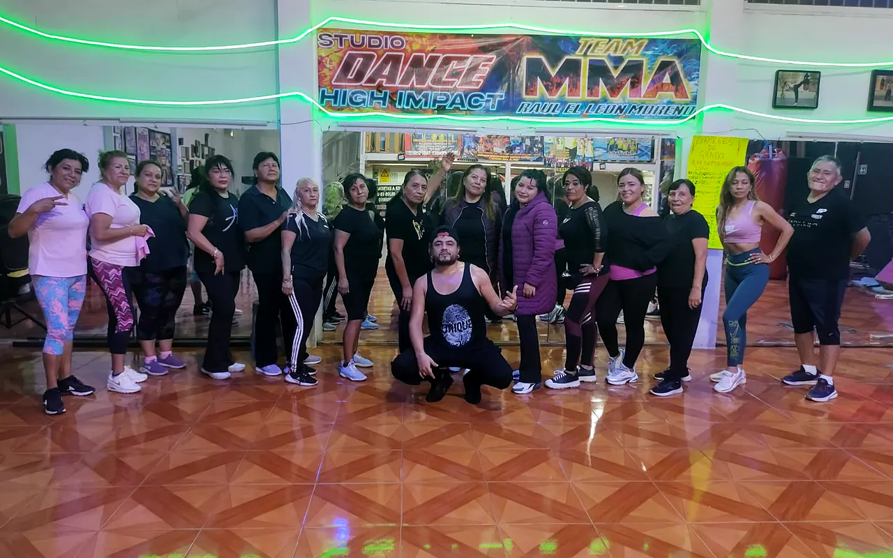 Grupo con ropa rosa y negra en el estudio de piso de madera