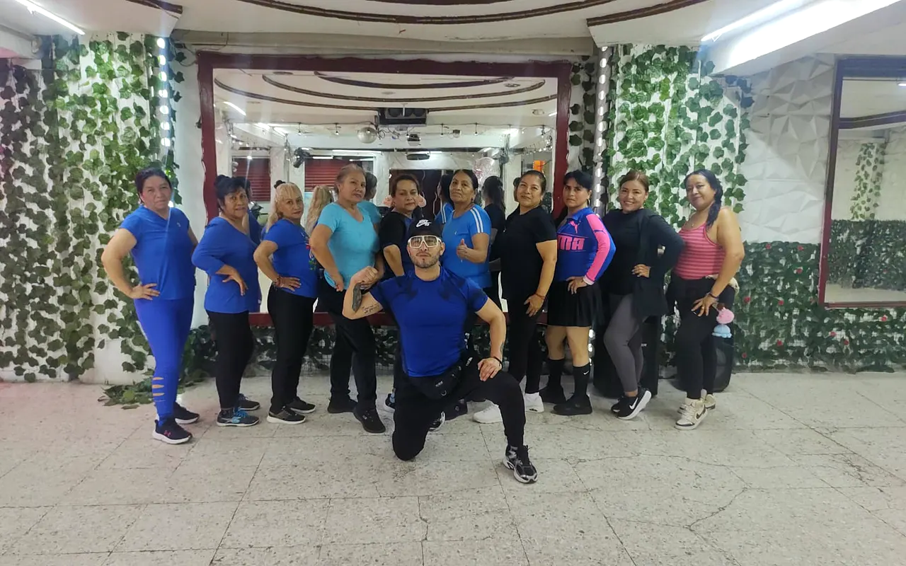 Grupo vestido de azul posando con el instructor al centro
