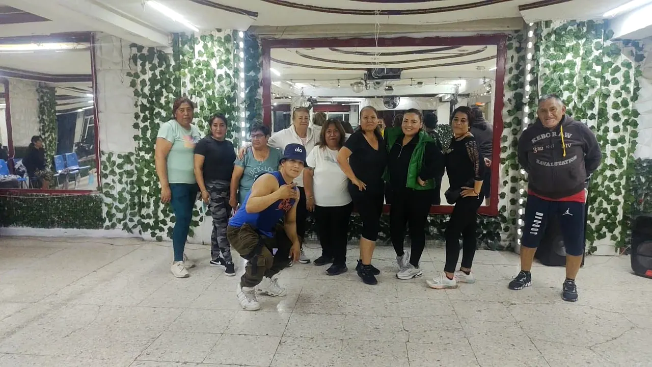 Grupo posando frente a los muros de hojas del salón